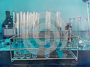 Liquid in test tubes in a test tube rack against a blue background