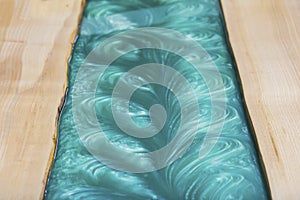 Liquid turquoise epoxy on the kitchen table in the workshop