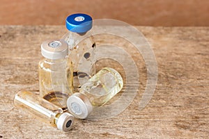 Liquid vial on wooden table background