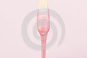 liquid wax for pink depilation drains from the stick. The concept of depilation, waxing,