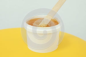 Liquid yellow paste for shugaring on yellow background