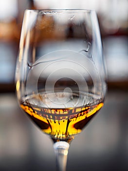 Liquor bottles reflected in whisky filled wine glass, vertical, Kyoto, Japan