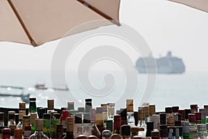 Liquor Bottles in a Tropical Beach Bar with Cruise Boat