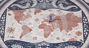 Lisbon - Aerial view of tourist man standing on the giant mosaic of a world map and compass at the discoveries monument, Lisbon