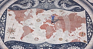 Lisbon - Aerial view of tourist man standing on the giant mosaic of a world map and compass at the discoveries monument, Lisbon photo