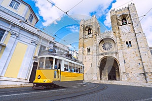 Lisbon city and famous yellow tram 28 in front of Santa Maria cathedral