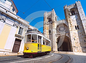 Lisbon city old town and famous yellow tram 28 in front of Santa Maria cathedral