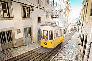 Lisbon city old town narrow streets and tram, Portugal. Famous retro yellow funicular tram on a sunny summer day