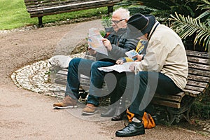 Lisbon, Portugal 01 may 2018: Pensioners or elderly people plan voyage. Tourists pensioners plan trip or sit on bench