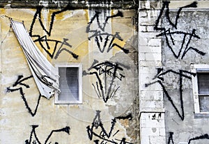 Old damaged house facade with window and curtain