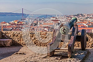 Lisbon, Portugal. Old bronze cannon in Sao Jorge aka Saint George Castle and a view of Lisbon Baixa Distric photo