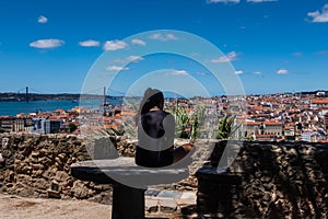 Lisbon, Portugal, rear view of teenage girl sitting alone. Scenic view of the city