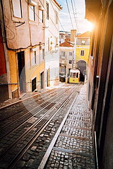 Lisbon`s Gloria yellow funicular in sunset beam light. Lisbon, Portugal. West side of the Avenida da Liberdade connects