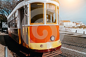 Lisbon traditional red tram on a street in Alfama district near terasse. Portugal, Europe