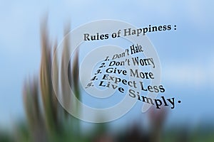 List of happiness rules - Do not hate, do not worry, give more, expect less, live simply. On blurry illustration background of