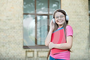 Listen for education you want. Happy child wear headphones outdoors. Listen technologies. Listening comprehension photo