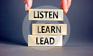 Listen learn lead symbol. Concept word Listen Learn Lead on beautiful wooden block. Businessman hand. Beautiful grey table grey