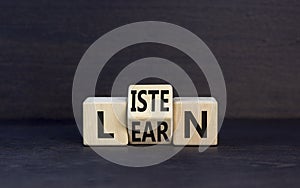 Listen and learn symbol. Concept word Listen Learn on wooden cubes. Beautiful black table black background. Business, education