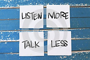 Listen more talk less, text words typography written on paper against wooden background, life and business motivational