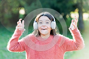 Listen in style. Little girl child wearing headphones. Happy child enjoy listening to music on the go. Adorable little