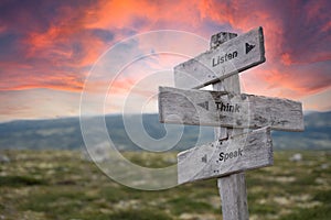 listen think speak text engraved in wooden signpost outdoors in nature during sunset