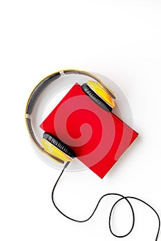 Listen to audio books with headphone on white background flatlay