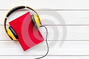 Listen to audio books with headphone on white wooden background flatlay mock up