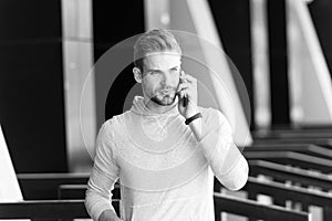 Listen to me. Man beard walks with smartphone, urban background. Man with beard serious face talk smartphone. Guy