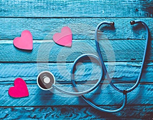 Listen to your heart. Checking the heart for diseases. The concept of care for the heart. Stethoscope, hearts on a blue wooden