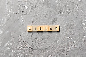 Listen word written on wood block. listen text on table, concept