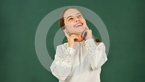 Listening audio book. Student girl in headphones at chalkboard background copy space. Audio translation. Audio learning