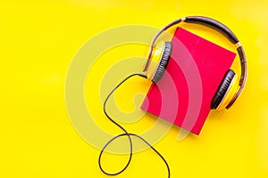 Listening audio books with headphones in library on yellow background top view space for text