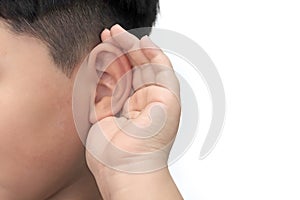 Listening concept boy waving his hand in his ear on a white background and listen carefully, Hearing aid