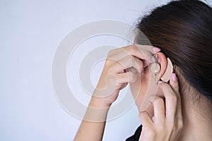 Listening concept. Woman shook her hand near the ear and listened carefully
