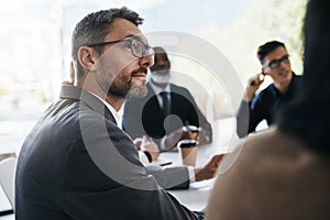 Listening keenly to whats being discussed around the table. a businessman having a meeting with his colleagues in an