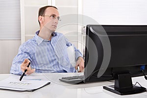 Listless sad and overworked business man sitting at desk with co