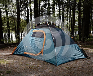 Lit backpacking tent at a forest campsite photo