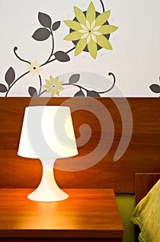 A lit bedside lamp