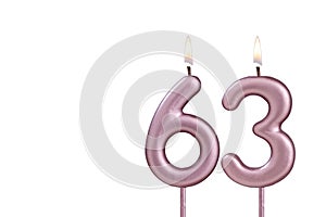 Lit birthday candle - Candle number 63 on white background