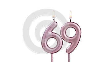 Lit birthday candle - Candle number 69 on white background