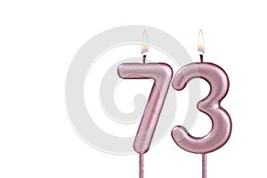 Lit birthday candle - Candle number 73 on white background