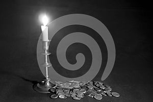 Lit candle and coins