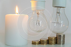 Lit candle, and unlit bulbs. Energy saving and rationing.