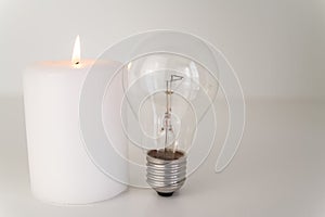 Lit candle, and unlit bulbs. Energy saving and rationing.