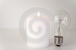 Lit candle, and unlit bulbs. Energy saving and rationing.