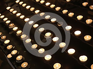 lit candles with the flame by pilgrims during the religious service inside the church