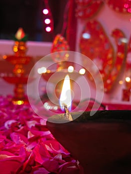 A lit diya on bed of roses