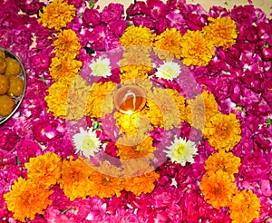 Lit diya on a floral hindu pattern photo