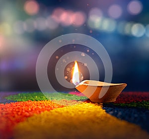 Lit diya lamp on an abstract background with shallow depth of field