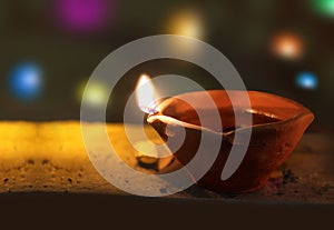 Lit diya lamp on street at night or beautiful diwali lighting, selective focus. clay diya lamps lit during diwali